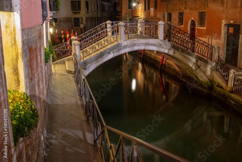 Quiet and calm still life small stone bridge spanning canal by night, Venice, Italy
