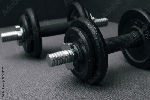 Fitness background. Two 10 kg dumbbells on a gray mat. Sports concept - gray mat, two black dumbbells 10 kg