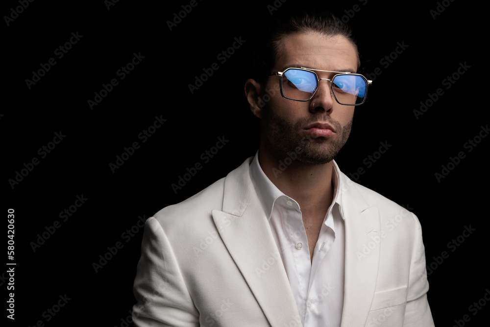 handsome elegant guy with open collar shirt wearing white suit posing