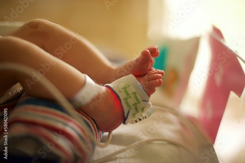 newborn baby feet closeup in hospital NICU with oxygen monitor equipment