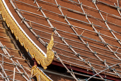 Temple Repair -  Bamboo scaffolding aids roof access to a temple. Wat Chedi Luang. Chiang Mai, Thailand