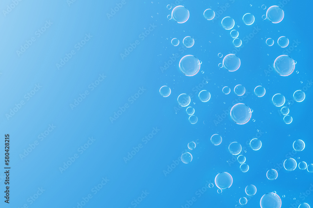 Air bubbles in the water.Hyaluronic acid or cosmetic oil drops on blue background.