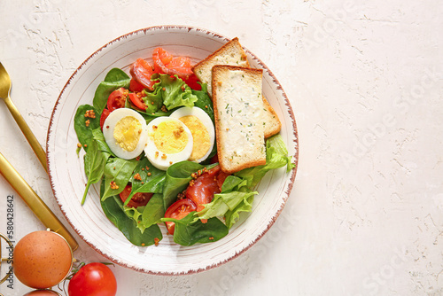 Plate of delicious salad with boiled eggs and salmon on white grunge background