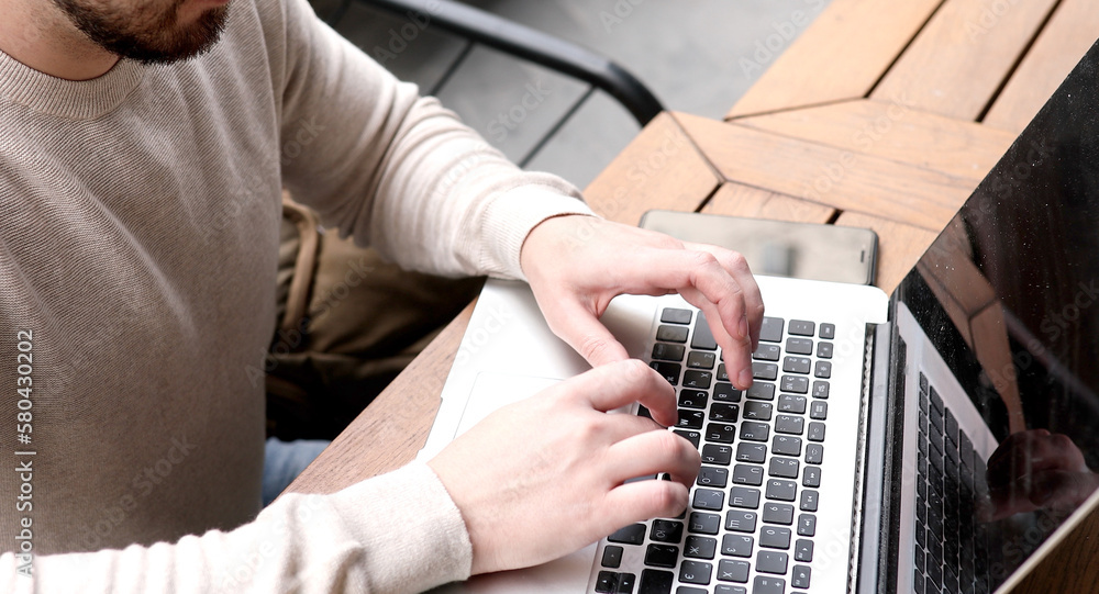 Close up hands multitasking man using laptop connecting wifi.