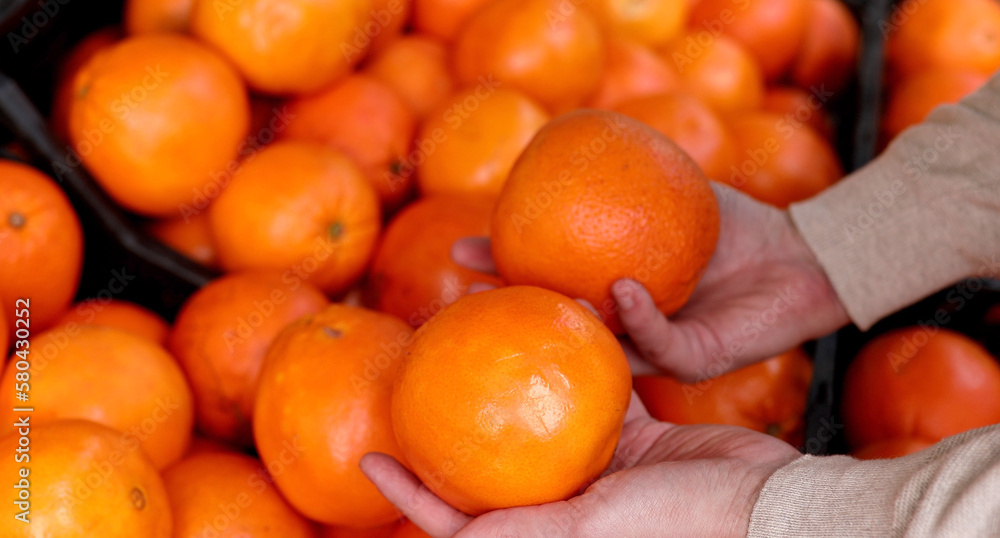 Shopping, food, sale, consumerism and people concept man buying oranges at grocery store or supermarket. Shopping, food, sale, consumerism and people concept man buying oranges at grocery store or supermarket.