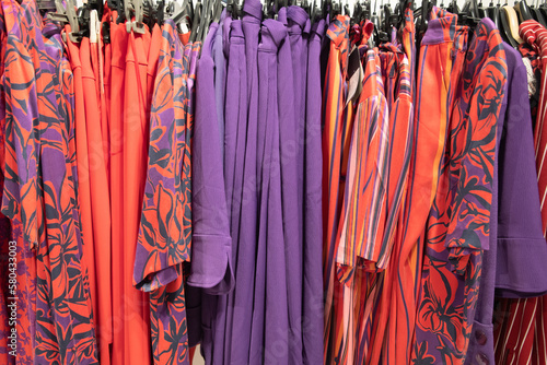 different models orange and purple blouses in the store grouped in the color