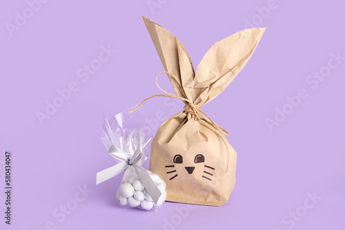 Easter bunny gift bag and candies on lilac background