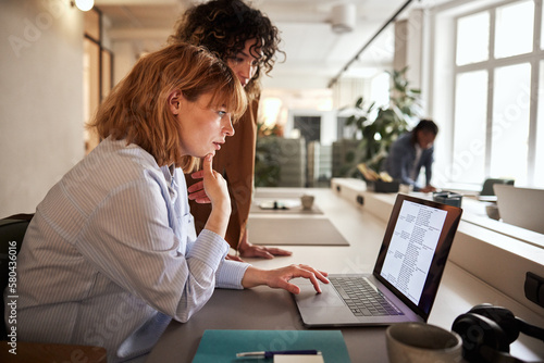 Businesswomen reading data on a laptop photo