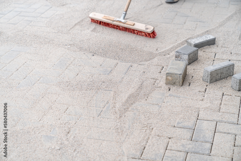 sweeping sand with a broom during the construction of a new pavement sweeping sand with a broom during the construction of a new pavement
