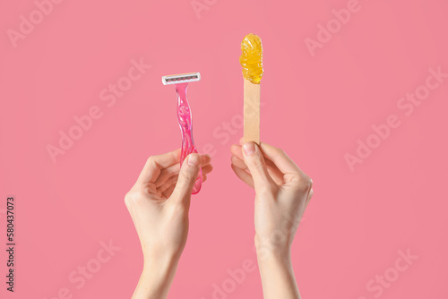 Konstfotografi Hands holding spatula with sugaring paste and razor on pink background