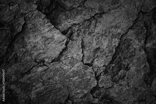 Cracked rock texture. Black white stone background. Grunge. Dark gray rough surface. Close-up. Broken, damaged, collapsed.
