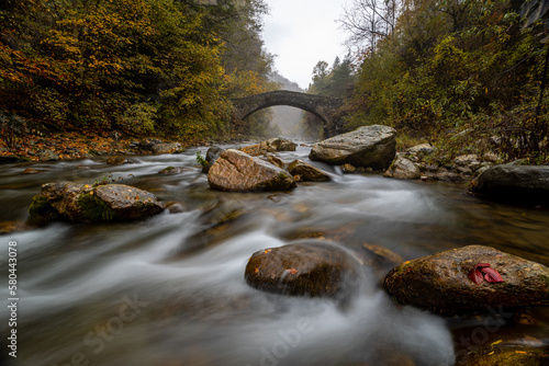 il torrente maira si insinua tra le rocce sotto il ponte del diavolo in una giornata d'autunno photo