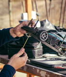 A man uses his hand and fingers to fix the motor engine in his RC car. Tools to prepare a radio control model vehicle.