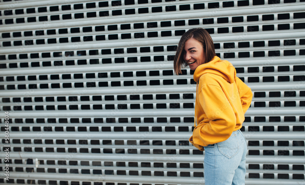 Handsome young female wearing yellow blank hoodie with space for your logo or design. Mockup for print