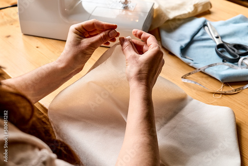 Photography Seamstress basting and sewing in a small studio