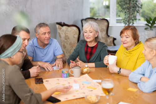 Retirees play board games and drink tea with cookies