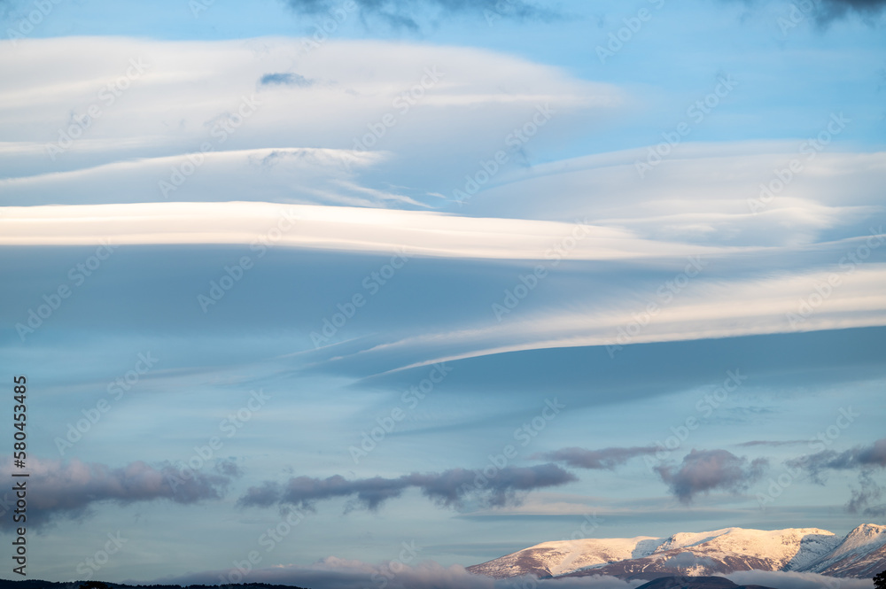 Panoramic view of large lenticular clouds over the snow-capped peaks of Sierra Nevada (Spain)