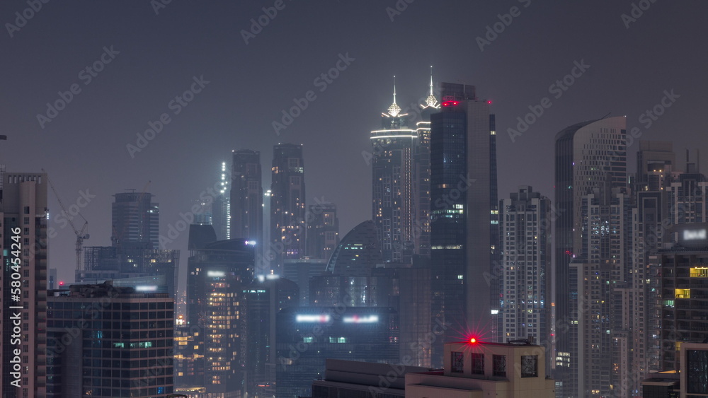 Naklejka premium Dubai skyscrapers with illumination in business bay district during all night timelapse.