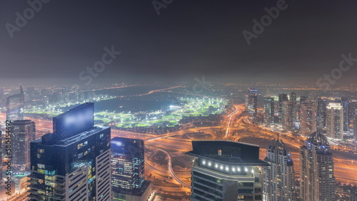 Panorama of Dubai Marina with JLT skyscrapers and golf course night timelapse, Dubai, United Arab Emirates.