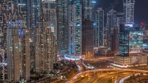 Aerial view on Dubai Marina with big highway intersection night timelapse and skyscrapers around, UAE