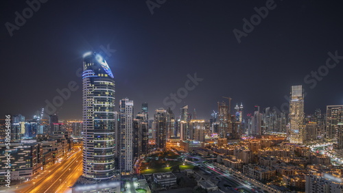 Panorama showing Dubai s business bay towers aerial night timelapse. Rooftop view of some skyscrapers