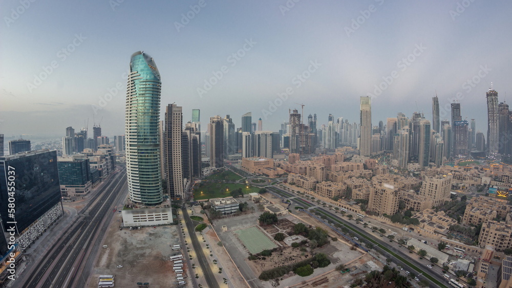 Dubai's business bay towers aerial night to day timelapse. Rooftop view of some skyscrapers