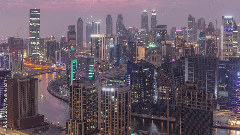 Obraz premium Skyline with modern architecture of Dubai business bay towers day to night timelapse. Aerial view