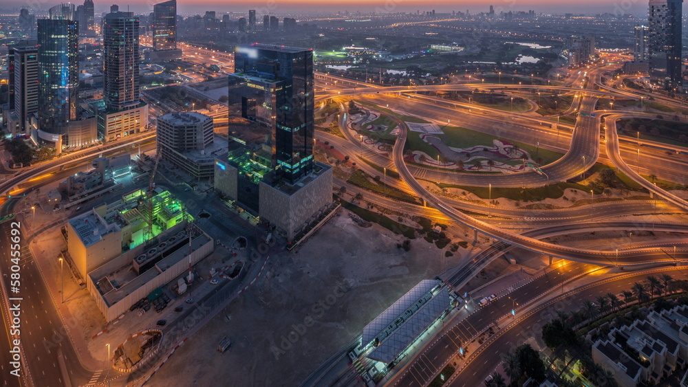 Fototapeta premium Aerial view of media city and al barsha heights district area night to day timelapse from Dubai marina.