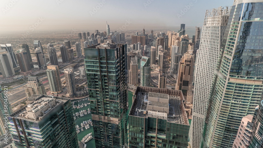 Fototapeta premium Panorama showing Dubai Marina and JLT with JBR district. Ttraffic on highway between skyscrapers aerial timelapse.