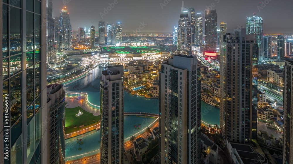 Dubai downtown with fountains and modern futuristic architecture aerial all night timelapse