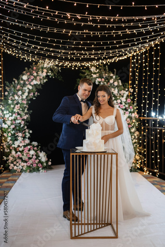 newlyweds happily cut and taste the wedding cake