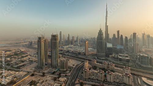 Panorama showing aerial view of tallest towers in Dubai Downtown skyline and highway timelapse.