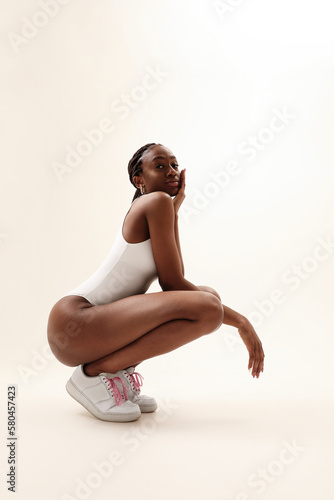 Young woman with perfect sporty body posing indoor. Vertical mock-up.