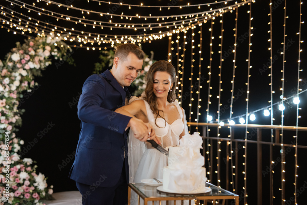 newlyweds happily cut and taste the wedding cake