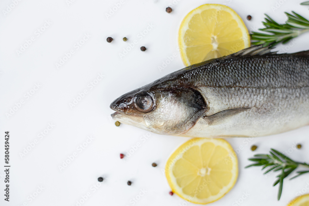 Fresh fish with spices and herbs on table in kitchen. Fresh sea bass. Fresh fish with spices and herbs on table in kitchen. Fresh sea bass.