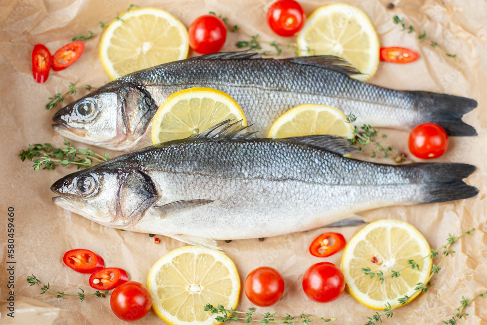 Fresh fish with spices and herbs on table in kitchen. Fresh sea bass. Fresh fish with spices and herbs on table in kitchen. Fresh sea bass.
