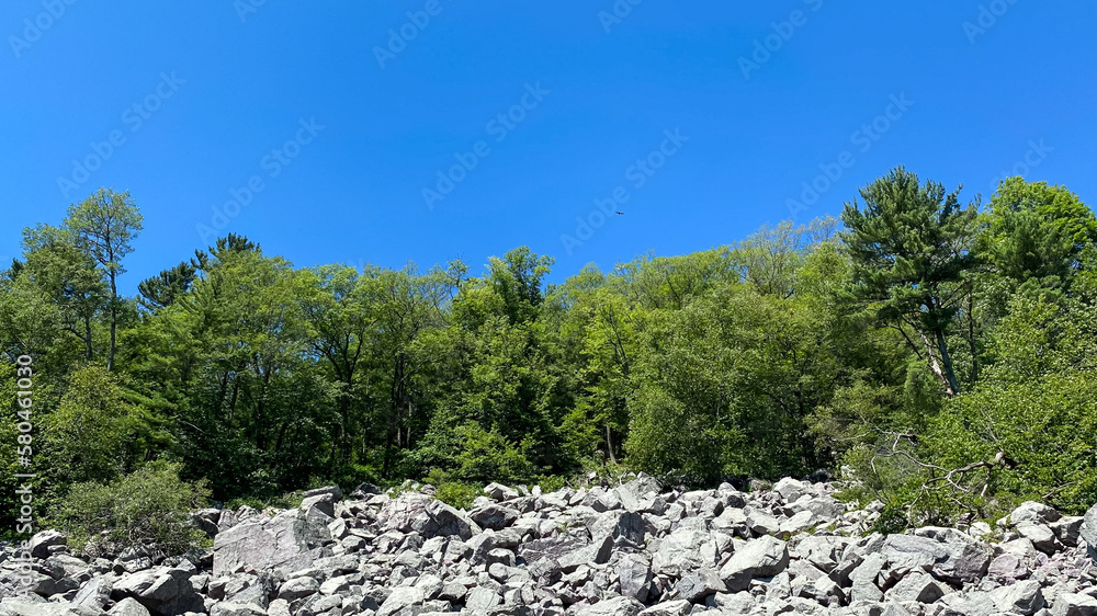 granite rocks on bluff with trees on top with blue sky granite rocks on bluff with trees on top with blue sky