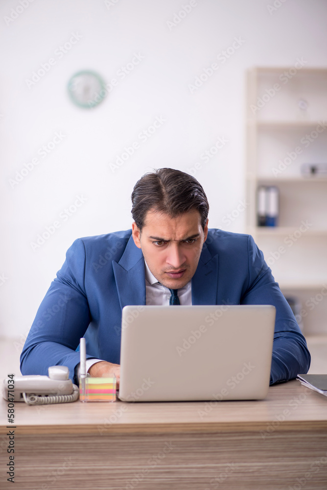 Young male employee working in the office Young male employee working in the office