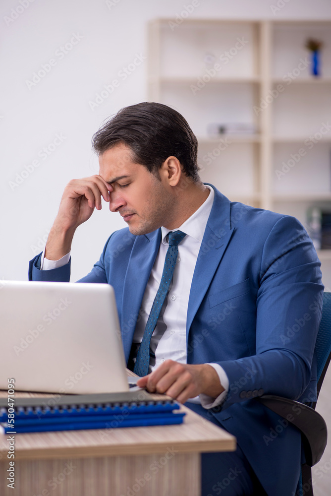 Young male employee working in the office Young male employee working in the office