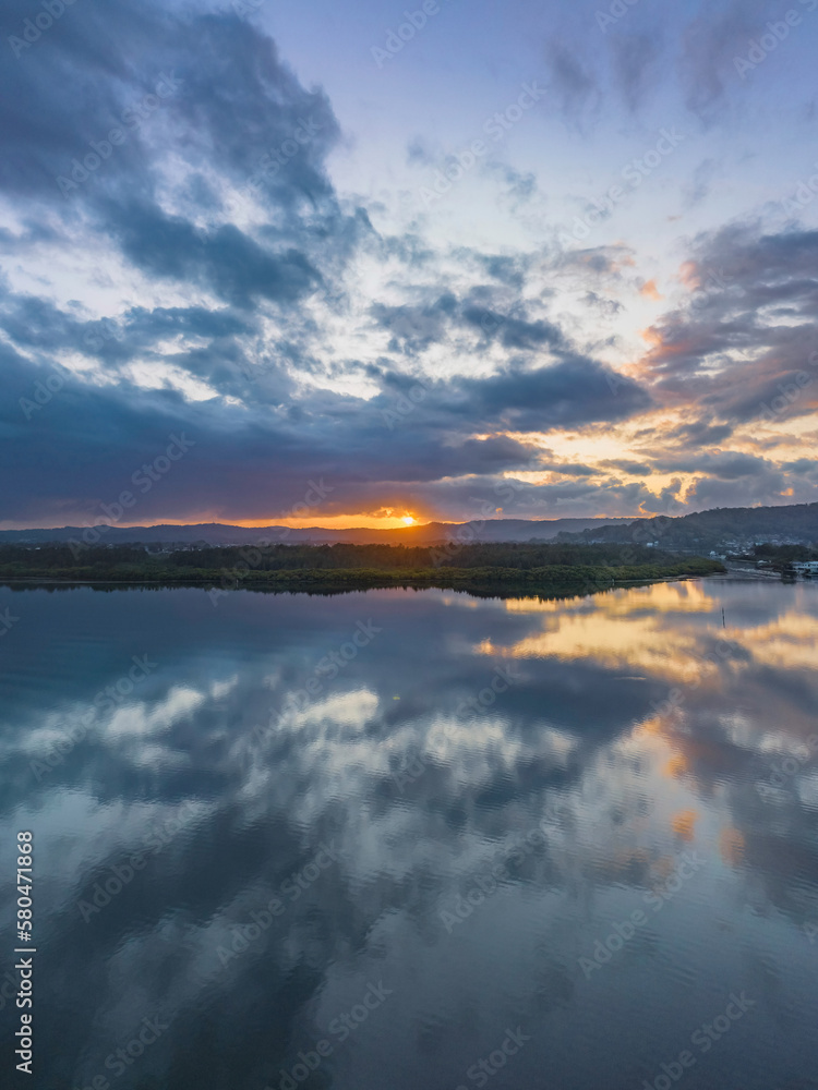 Sunrise waterscape with rain clouds and reflections
