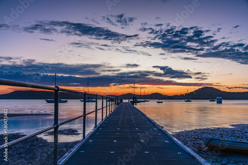 Sunrise along the Jetty with boats and clouds