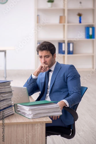 Young male employee and too much work in the office