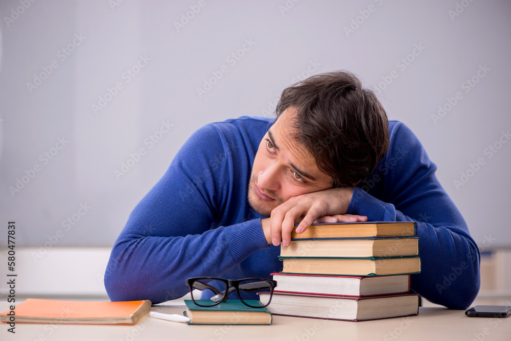 Young male student preparing for exams in the classroom Young male student preparing for exams in the classroom
