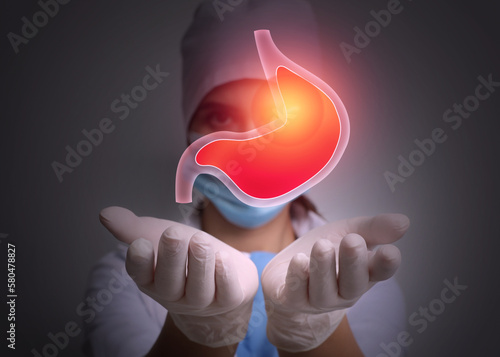 Treatment of heartburn and other gastrointestinal diseases. Doctor holding stomach illustration on dark background,