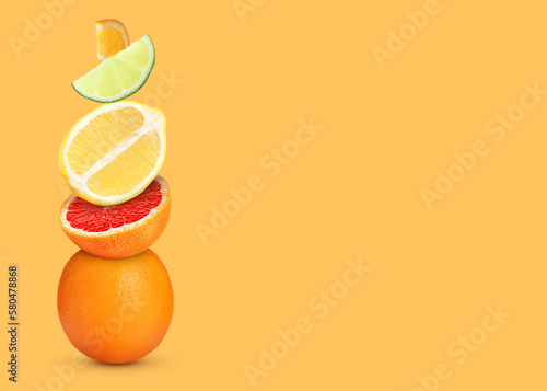 Stack of different fresh citrus fruits on pale orange background  space for text