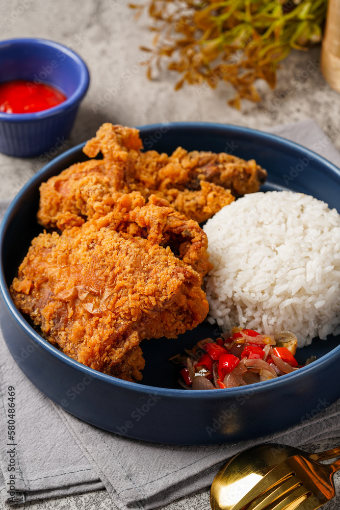 Ayam Geprek is an Indonesian Food crispy fried chicken with hot and spicy sambal Chili Sauce. Ayam Geprek is an Indonesian Food crispy fried chicken with hot and spicy sambal Chili Sauce.