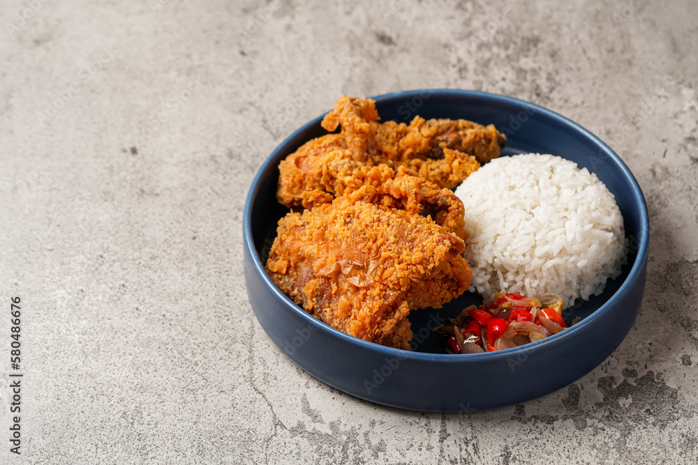 Ayam Geprek is an Indonesian Food crispy fried chicken with hot and spicy sambal Chili Sauce. Ayam Geprek is an Indonesian Food crispy fried chicken with hot and spicy sambal Chili Sauce.