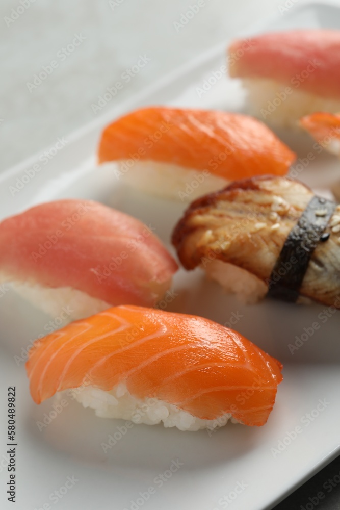 Plate with delicious nigiri sushi on grey table, closeup Plate with delicious nigiri sushi on grey table, closeup