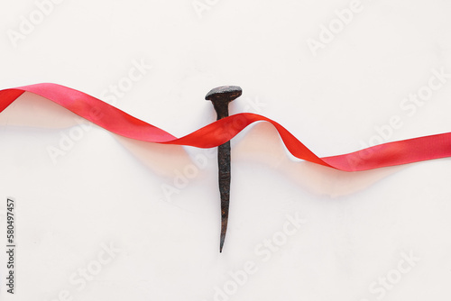 Stampa su tela A nail with a red ribbon, a symbol of Christ