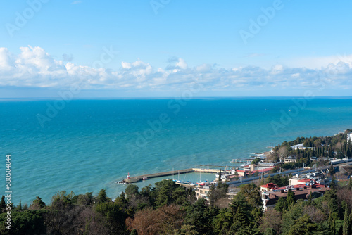 View of Sochi city on a sunny winter day with bright blue sky with white clouds and blue sea. Nature background with selective focus. Travel concept